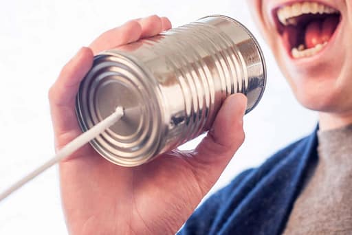 person talking into a tin can phone
