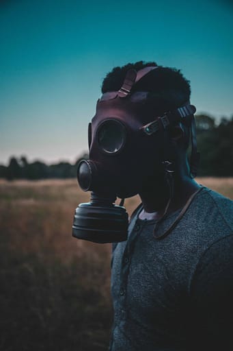 man in a gas mask in a field